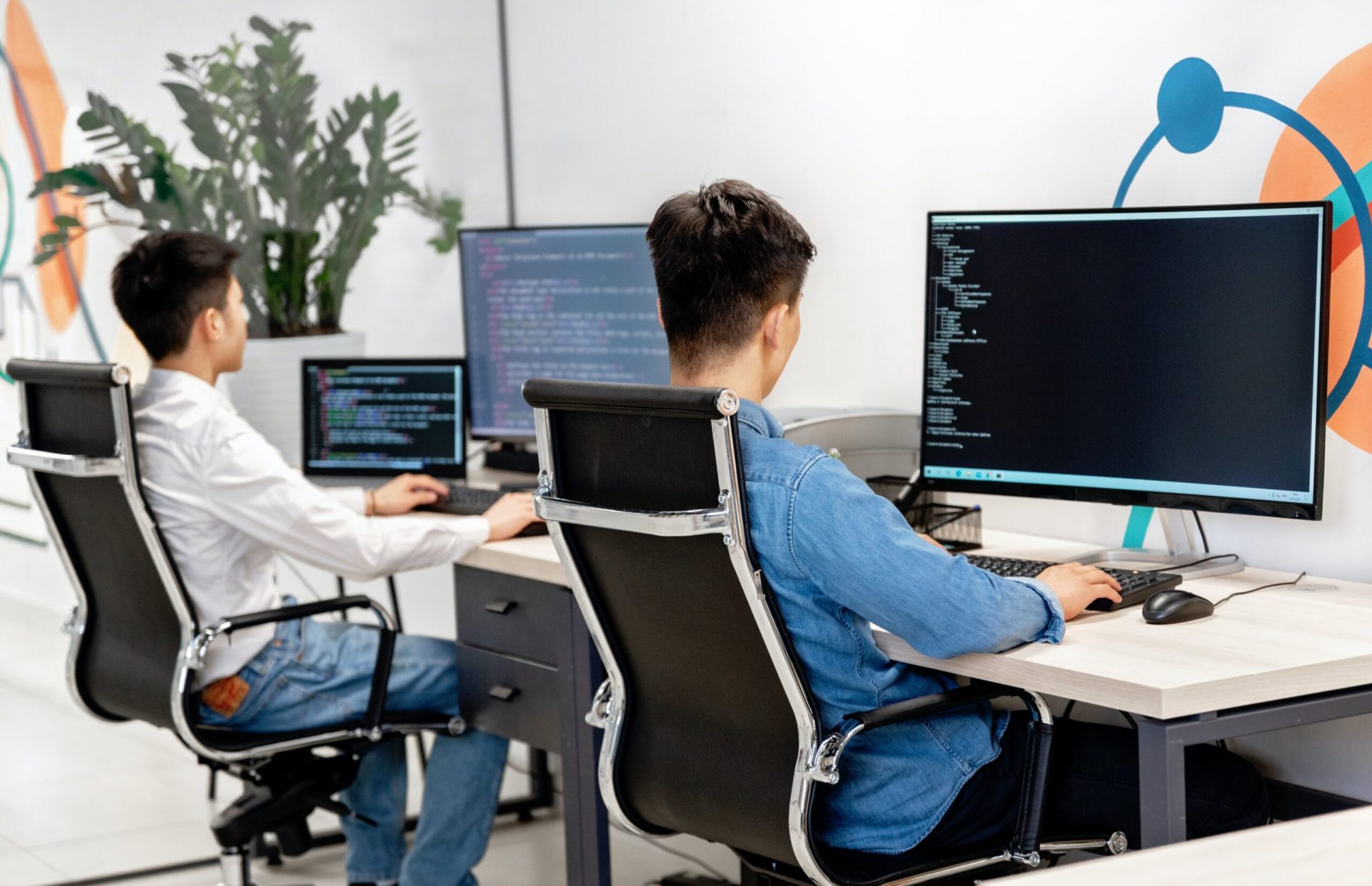 Two Individuals Working on Computers in an Office Environment